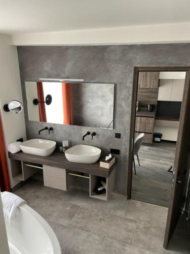 a bathroom with two sinks and a large mirror at Nepomuk rooms in Vipiteno