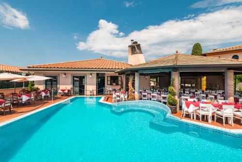 a pool with chairs and tables and a building at Hotel la Pietra restaurant in Fosdinovo