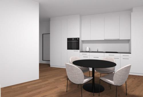 a kitchen with a black table and white chairs at MOOI Apartments Grenchen in Grenchen