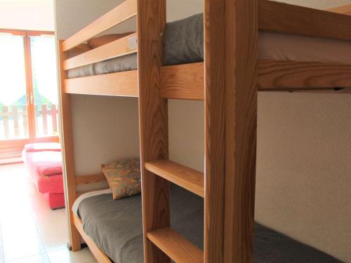 two wooden bunk beds in a room with a bed at Appartement Vars, 2 pièces, 4 personnes - FR-1-330B-69 in Vars