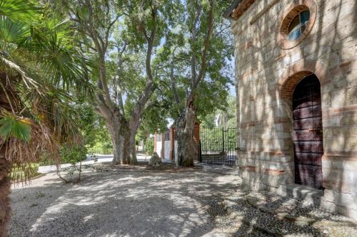 an old brick building with trees in the background at Villa Vetta Marina - My Extra Home in Sirolo