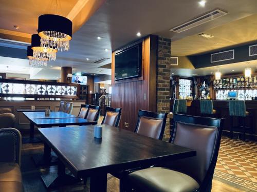 a restaurant with tables and chairs and a television at The Terrace Hotel in Magherafelt