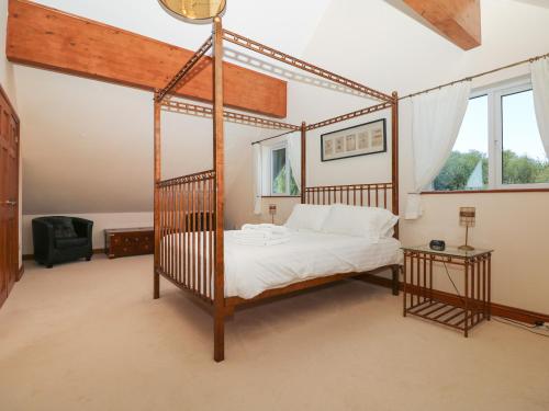 1 dormitorio con cama con dosel y ventana en Willow Lodge, Retallack, en Saint Columb Major