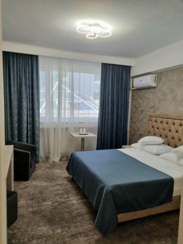a hotel room with a bed and a window at Hotel Tiara in Ploieşti