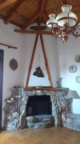 a living room with a stone fireplace with a chandelier at Seaside Apartment in Agios Nikolaos