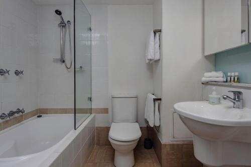 e bagno con servizi igienici, vasca e lavandino. di Oceans Eleven at Iluka Resort Apartments a Palm Beach