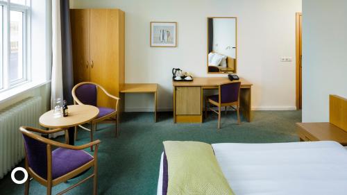 a hotel room with a bed and a table and chairs at Center Hotels Skjaldbreid in Reykjavík