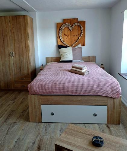a bedroom with a large bed with a heart headboard at Ferienapartment-Barbara in Langscheid