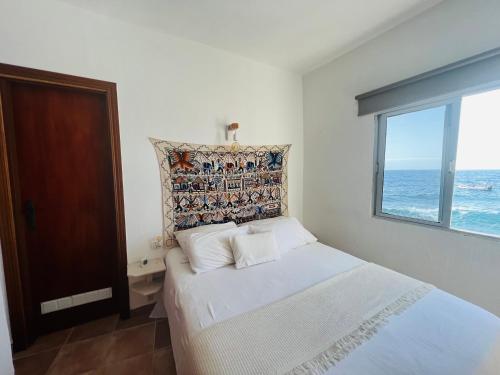 1 dormitorio con 1 cama y vistas al océano en Maravillosas vistas al mar "Primera Línea" Apartamentos Can Toca - Seahouses en Santa Cruz de Tenerife