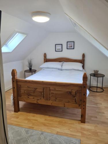 a bedroom with a wooden bed in a attic at Fisherman Cottage by Langley Serviced Apartments Contractor-Friendly 2BR Stay Sleeps 4 Free WiFi Free Parking 20 Minutes to Banniskirk in Wick