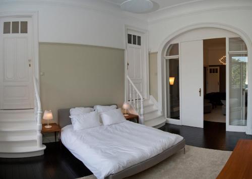 - une chambre avec un grand lit blanc et des oreillers blancs dans l'établissement Appartement Chic, à Bruxelles