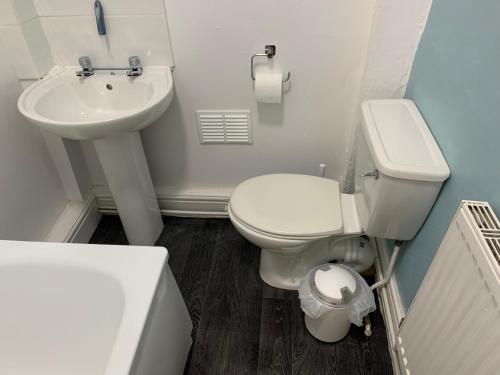 a bathroom with a white toilet and a sink at Cosy Wirral home near Liverpool with Free Parking! in Birkenhead