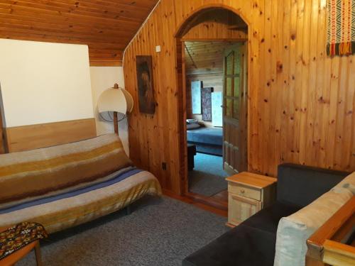 a bedroom with a bed and a living room at Chata u Sylwii in Okuninka