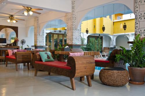 un vestíbulo con un montón de sillas y mesas en Riad Hua Hin en Hua Hin