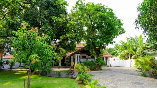 uma casa com árvores e uma entrada de tijolos em Flamingo Villa em Jaffna