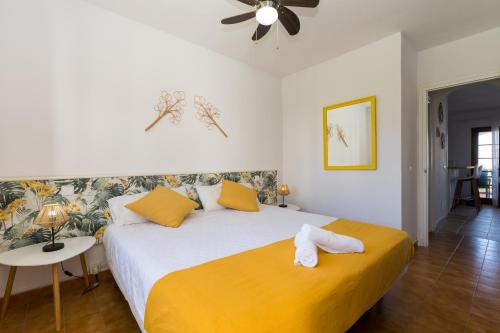 una camera da letto con un grande letto con lenzuola gialle e cuscini gialli di Apartamento recién reformado en Cala en Porter a Cala'n Porter