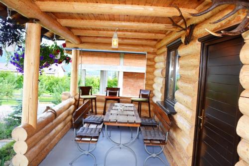 eine Terrasse mit einem Tisch und Stühlen darauf in der Unterkunft Cabana Raul in Gura Humorului