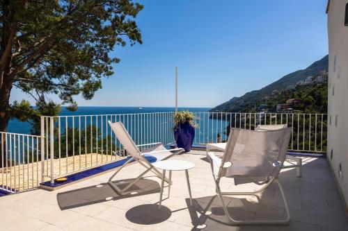 a balcony with chairs and a view of the ocean at Decori Suites Amalfi Coast in Vietri sul Mare
