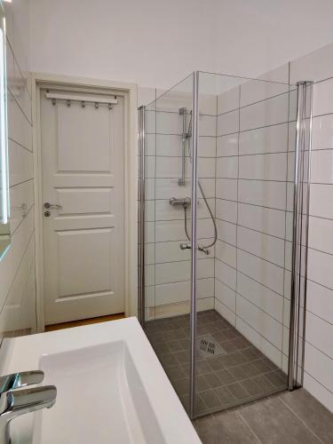 a bathroom with a shower with a tub and a glass door at Kongsgata Apartments in Figgjo