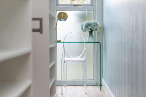 a glass table with a vase of flowers and a mirror at Playfair Terrace in St Andrews