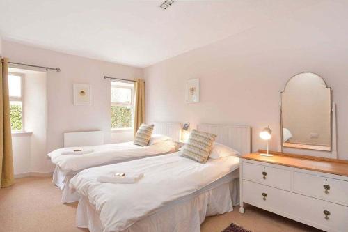 two beds in a bedroom with a mirror and a dresser at Kittocks Muir in St. Andrews