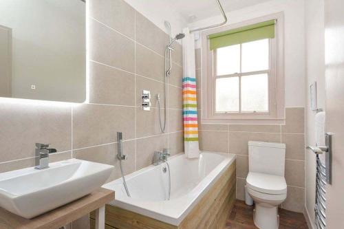 uma casa de banho com uma banheira, um lavatório e um WC. em Kittocks Muir em St. Andrews