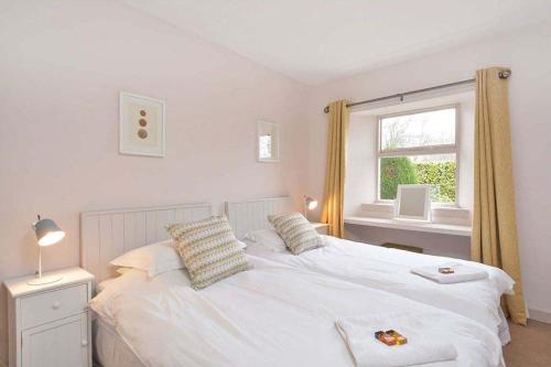 um quarto com uma cama branca e uma janela em Kittocks Muir em St. Andrews