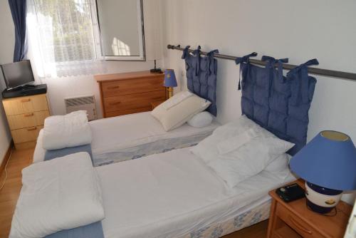 een woonkamer met 2 bedden en een blauwe lamp bij Appartement 2 pièces RDC jardin dans résidence avec piscine in Arzon