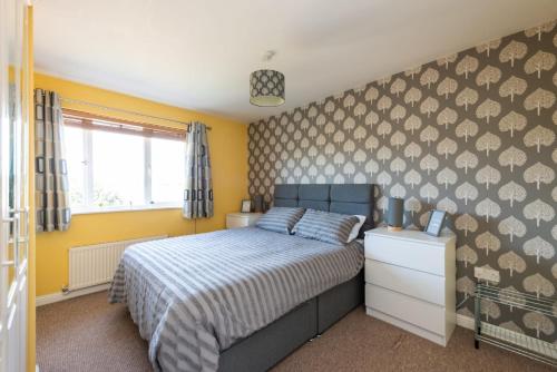 a bedroom with a bed and a yellow wall at Beautiful & Modern Seaside Home in Dunbar