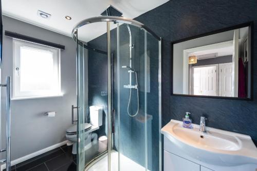 a bathroom with a glass shower and a sink at Beautiful & Modern Seaside Home in Dunbar