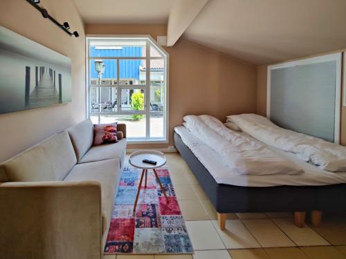 un soggiorno con 2 letti e un divano di Kongsgata Apartments 