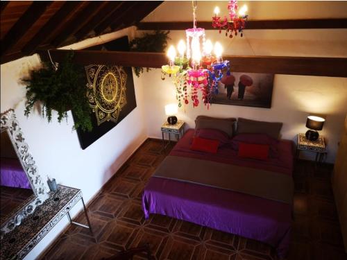 a bedroom with a large bed and a chandelier at Suite Zen y Cueva Refugio in Tenteniguada