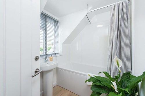 une salle de bain blanche avec un lavabo et une baignoire dans l'établissement Willow Cottage, North Street, à St Andrews