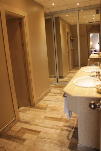 a bathroom with two sinks and two mirrors at Hotel Palacio del Mar in Santander