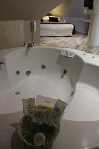 a bathroom with a sink and a bowl of toiletries at Hotel Palacio del Mar in Santander