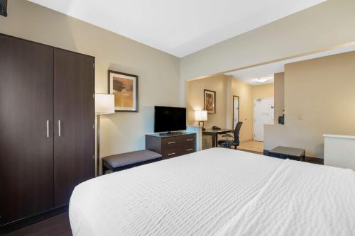 a hotel room with a white bed and a desk at Best Western Hilliard Inn & Suites in Hilliard
