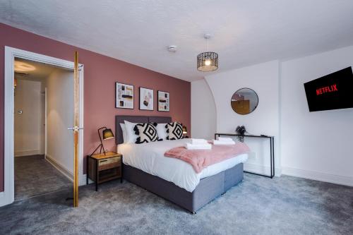een slaapkamer met een bed met een roze muur bij Faulkner House in Chester