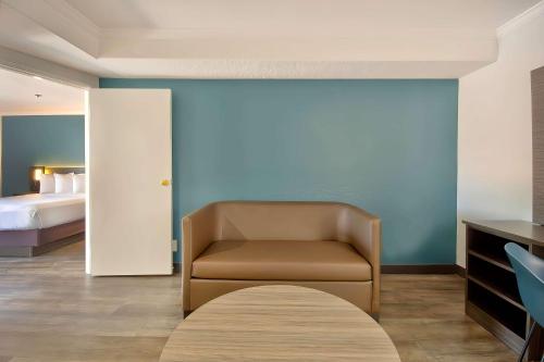 a hotel room with a chair and a bed at Studio 6 Suites Lawndale, CA South Bay in Lawndale