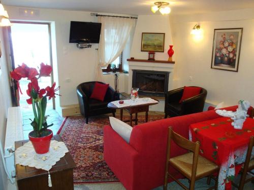 a living room with a red couch and a fireplace at Kleopatras 2 in Tsagarada