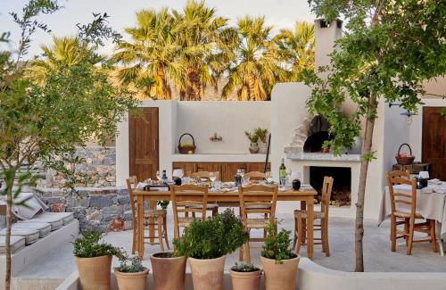 a patio with a table and chairs and a fireplace at Village Heights Resort in Hersonissos