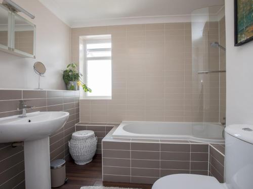een badkamer met een bad, een wastafel en een toilet bij Pass the Keys Stylish 2 Bedroom Flat Apartment with Free Parking in Windsor in Windsor
