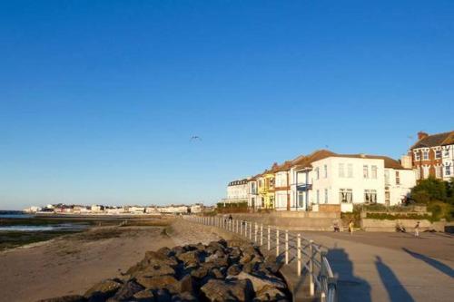 a beach with buildings and a fence and rocks at Sea-view Panorama in Margate