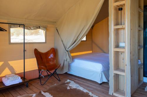 a bedroom with a bed and a chair in it at Tenuta San Lodovico in Scansano