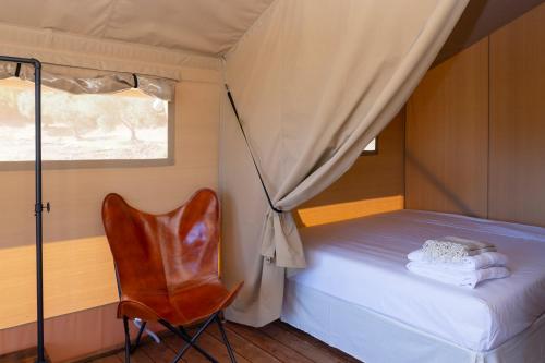 a bedroom with a bed and a chair and a window at Tenuta San Lodovico in Scansano