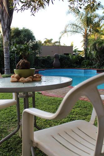 a table with a chair and a table with a bowl on it at Salveo Self-Catering Accommodation in Kimberley