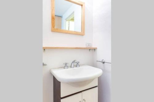 uma casa de banho com um lavatório e um espelho na parede em ESTUDIO A 20M DEL CENTRO CIVICO- VISTA AL LAGO em San Carlos de Bariloche