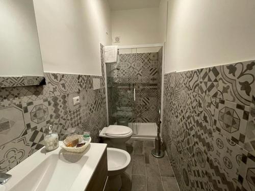 a bathroom with a toilet and a sink and a tub at Al Cortile in Reggio di Calabria