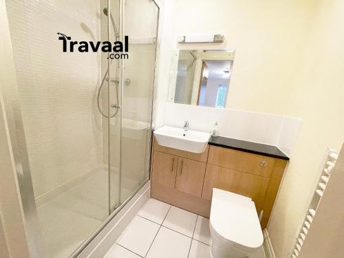 y baño con ducha, lavabo y aseo. en Travaal.©om - 2 Bed Serviced Apartment Farnborough en Farnborough