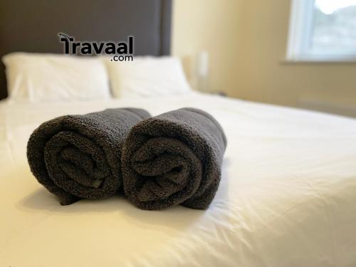 Dos toallas están encima de una cama. en Travaal.©om - 2 Bed Serviced Apartment Farnborough en Farnborough