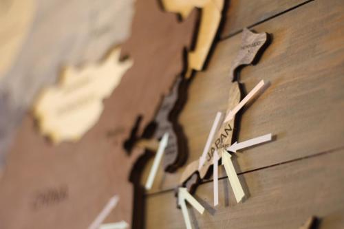 a clock on a wooden wall with arrows on it at 晴家(HALELUYA) Guest House in Fujikawaguchiko